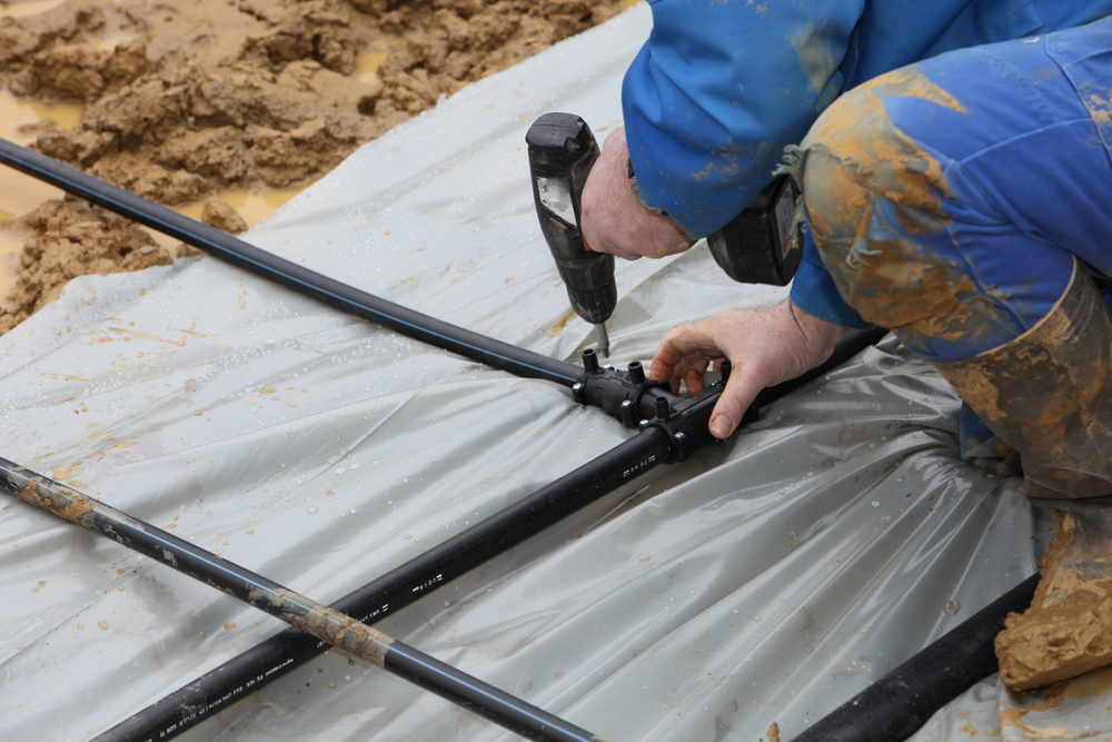 A contractor installs geothermal pipes in the ground