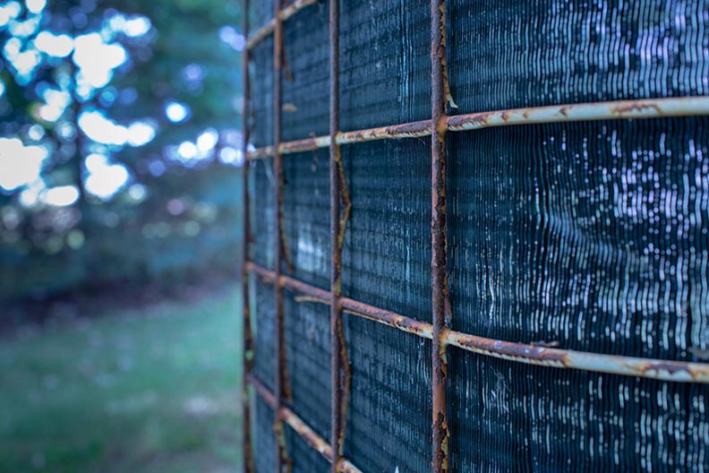 Rusty AC Condenser Side Grate with Dirty Cooling Fins