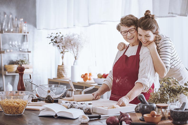 Granddaughter hugging grandmother in the kitchen