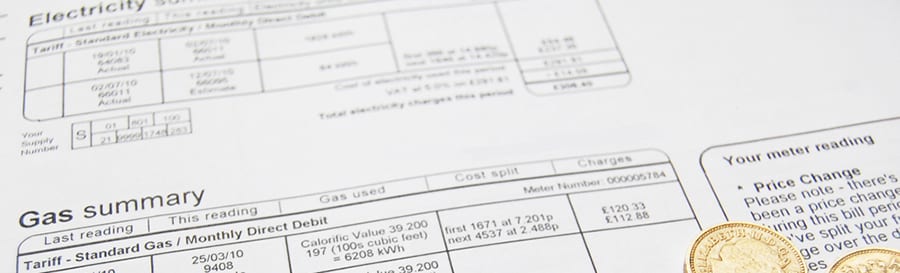 Energy bill and coins on table