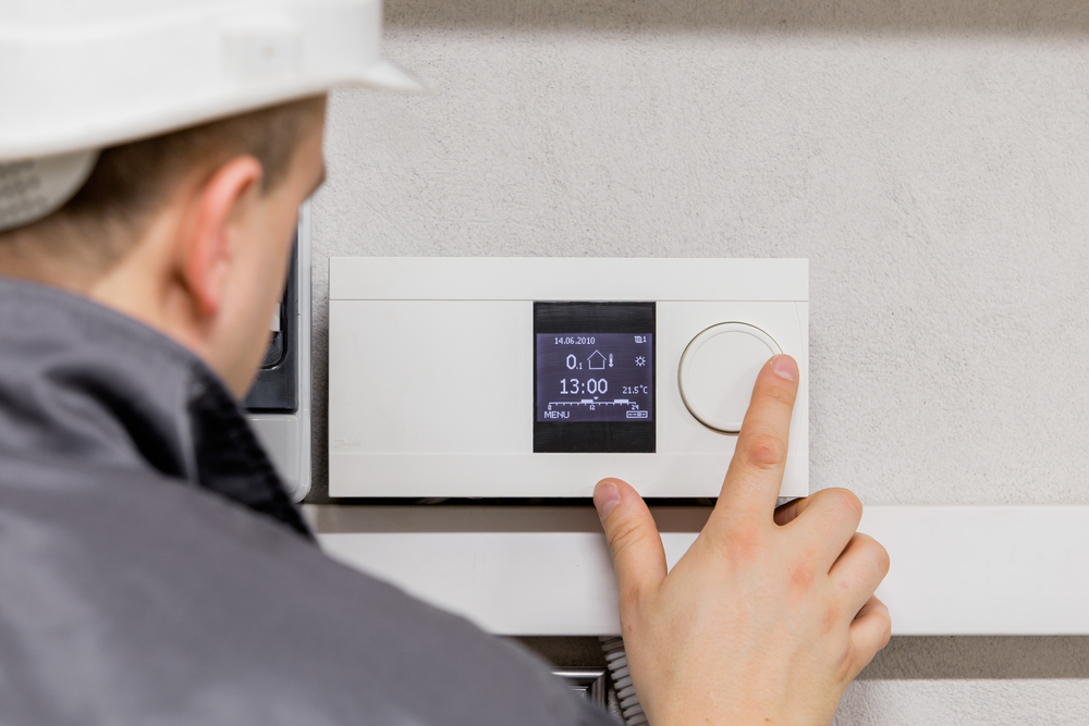 Engineer adjusting a thermostat