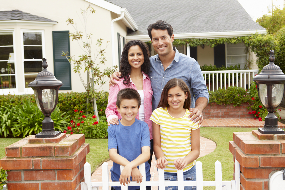 Happy family smiling outside their home