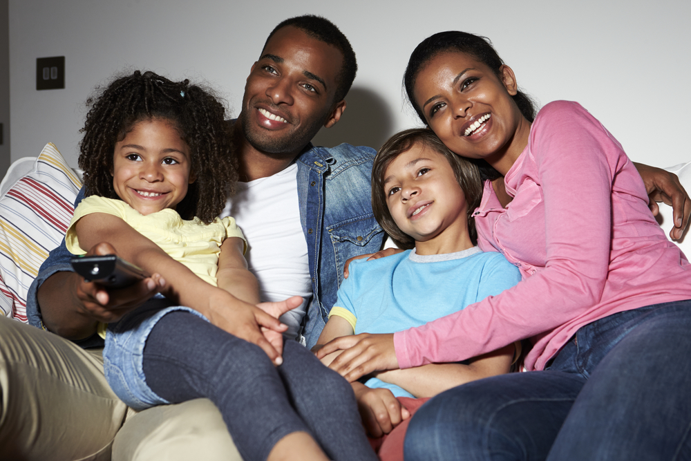 Family watching television together smiling